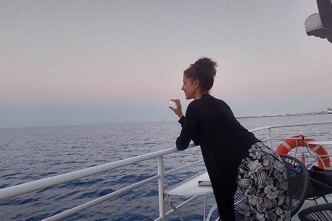 Rhodes Sunset Cruise - Swim and Dine w/ Live Music & Sunset! - Passing Rhodes’ illuminated ports: big ships to luxury yachts