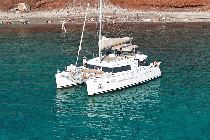 Santorini Catamaran Cruise: with Lunch, BBQ, Open Bar, Transfers - Red Beach swim stop: a one-hour hit of color