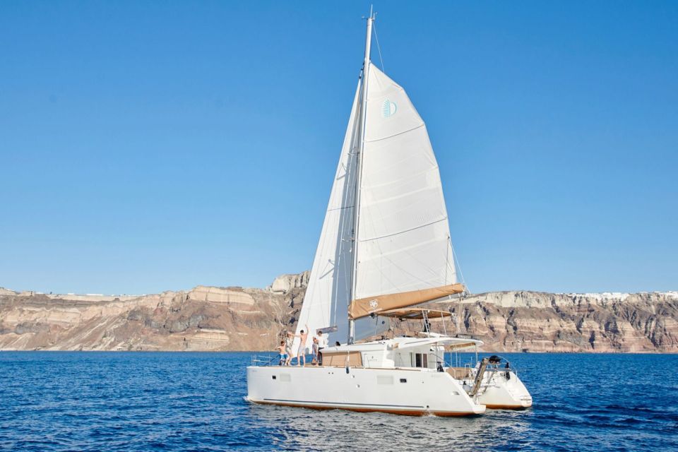 Santorini Gold Catamaran Cruise with Snorkel, BBQ & Open Bar - Back-to-back views: cliff-side villages from the sea
