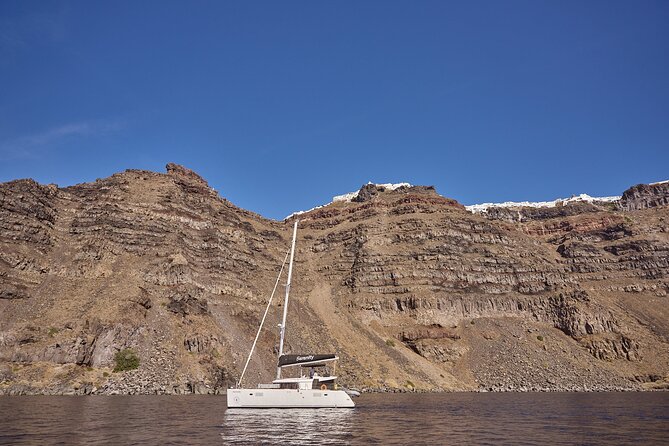 Santorini Oia: Luxury Sunset Cruise with Fresh Fish BBQ & Drinks - Stop 1: Thirassia for calm water, snorkeling gear, and easy swimming