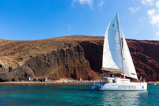 Santorini Private Catamaran Cruise with BBQ, Open Bar & Transfers - Red Beach at Akrotiri: The Iron-Rich Color Stop