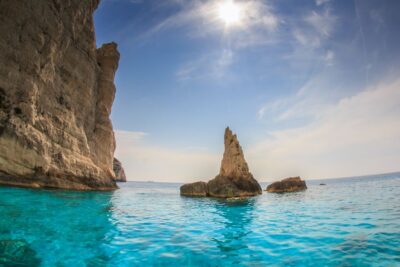 Zakynthos: Navagio Shipwreck Full-Day Cruise - Skinari details: lighthouse views, a turtle-shaped island, and Kefalonia on the horizon